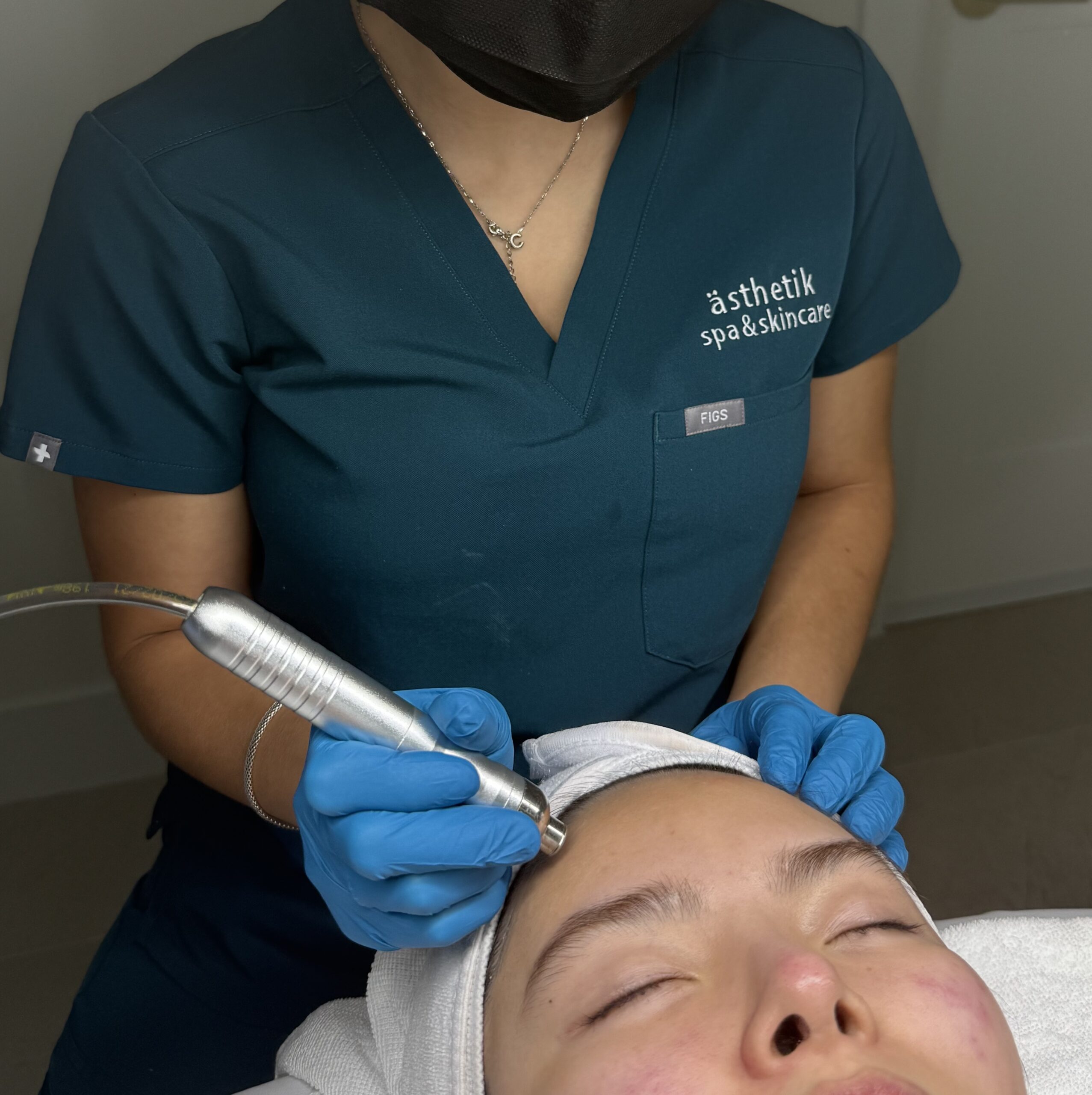 ästhetik esthetician performing a Hydrodermabrasion Facial treatment on a client
